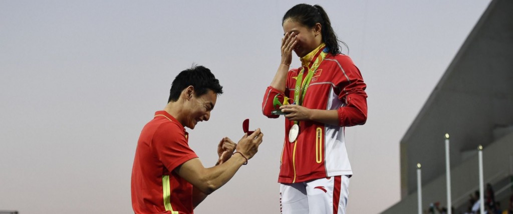 Silver medallist China's He Zi proposed to by Chinese diver Qin Kai after the podium ceremony of the Women's diving 3m Springboard Final at the Rio 2016 Olympic Games